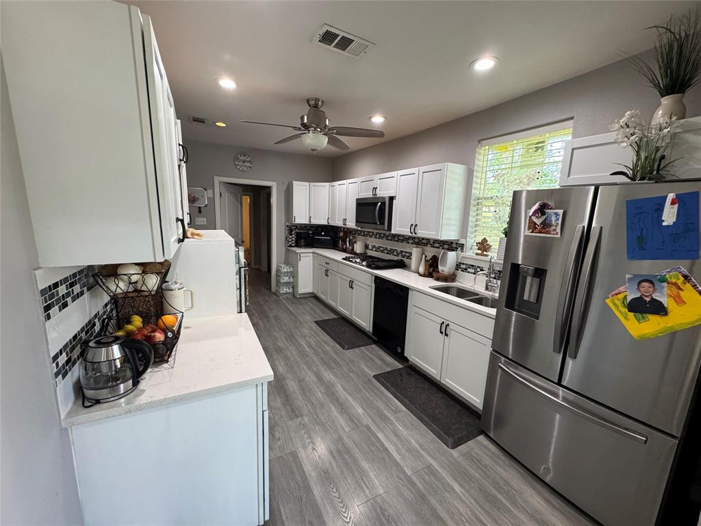 Kitchen with stainless steel appliances, tasteful backsplash, light stone countertops, white cabinets, and recessed lighting