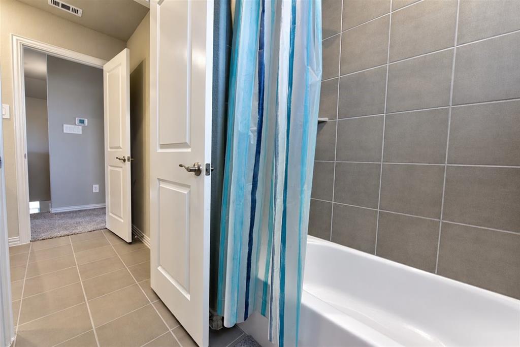 Bathtub with subway tile surround and coordinating tile flooring