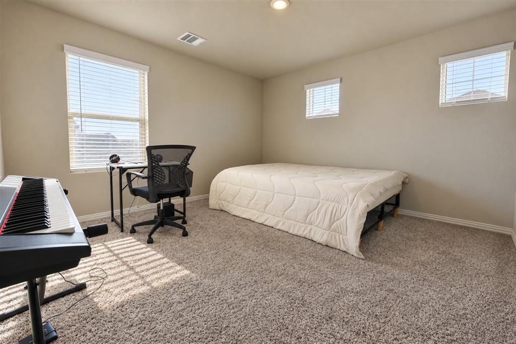 Carpeted room featuring multiple windows, recessed ceiling lighting, and neutral wall tones