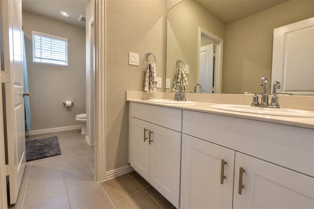 Dual vanity with white cabinetry and brushed nickel hardware, light-toned countertop, and undermount sinks