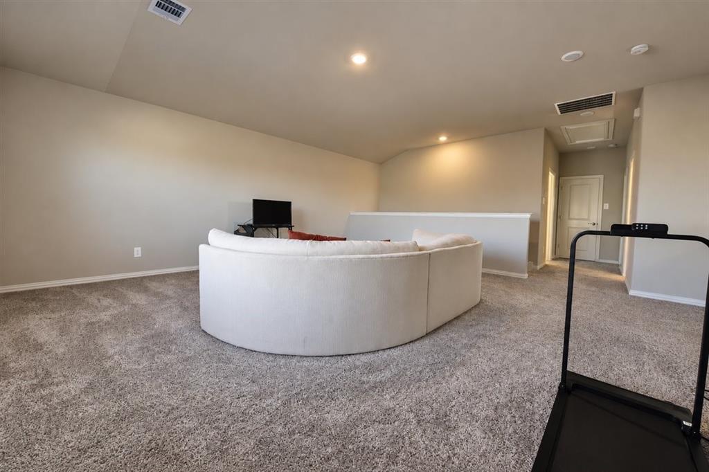 Carpeted upper level with vaulted ceiling, recessed lighting, and a partial wall separation