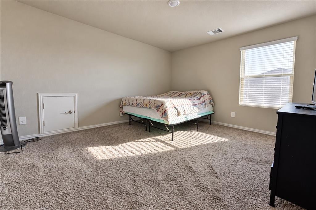 Wall-to-wall carpeting and a single window with horizontal blinds