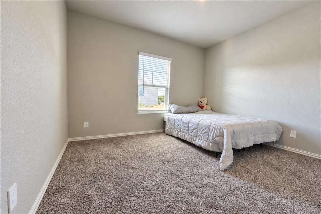 Textured wall finishes, window with blinds, and neutral carpeting
