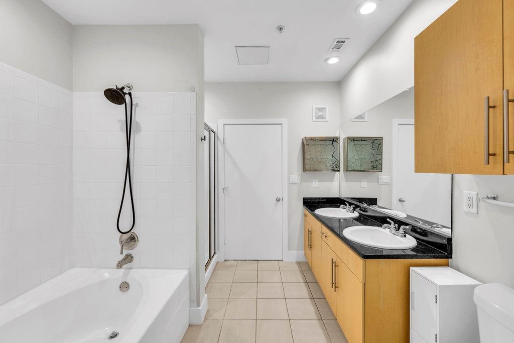 White tile tub and shower combination with a handheld showerhead