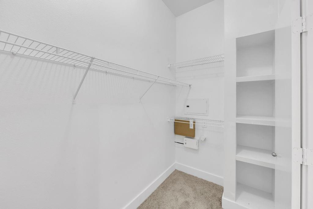 White wire shelving, built-in shelving unit, white walls, and carpet flooring