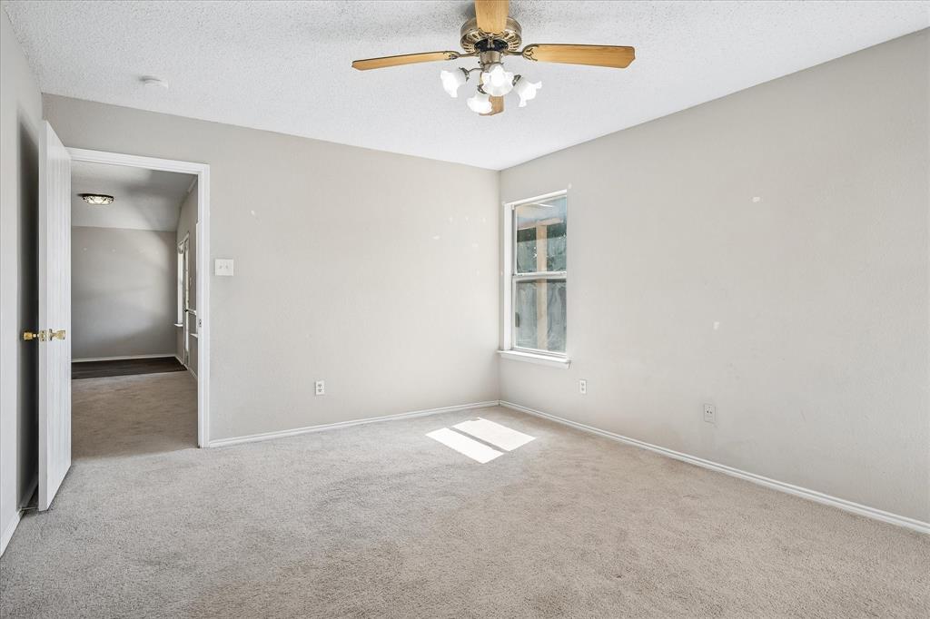 Neutral-toned carpeting, light gray wall paint, and a multi-pane window create a bright atmosphere