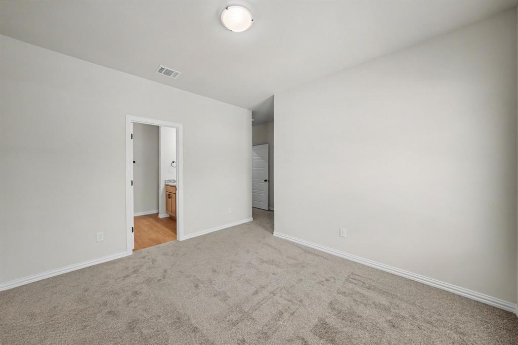 Neutral wall color, wall-to-wall carpeting, flush-mount ceiling light, and an open doorway