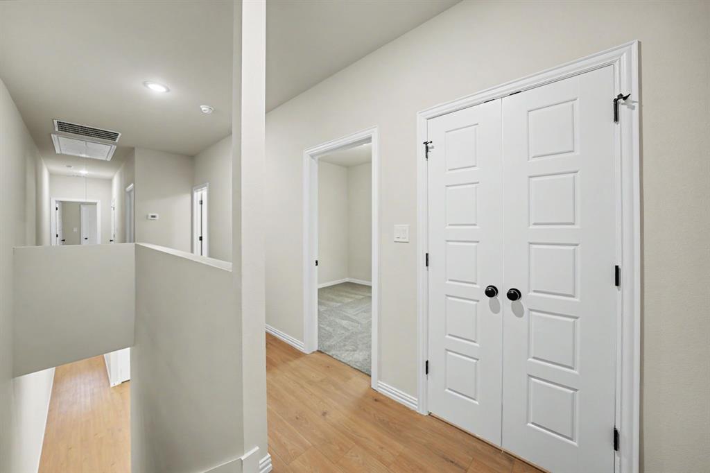 Hallway with wood-finish flooring, recessed lighting, and white walls