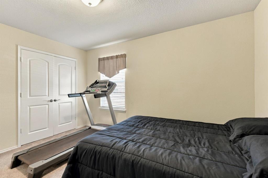 Room featuring neutral wall paint, carpeted flooring, a flush-mount ceiling light fixture, a window with horizontal blinds, and double-panel doors