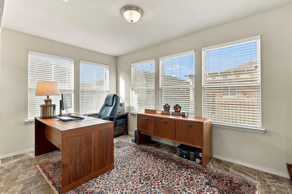 Room featuring tile flooring, neutral wall paint, and five windows with horizontal blinds