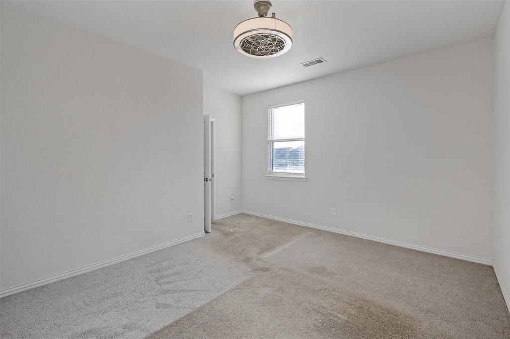 Neutral wall finishes, plush carpeting, single-pane window, and a drum-style ceiling fan with integrated lighting