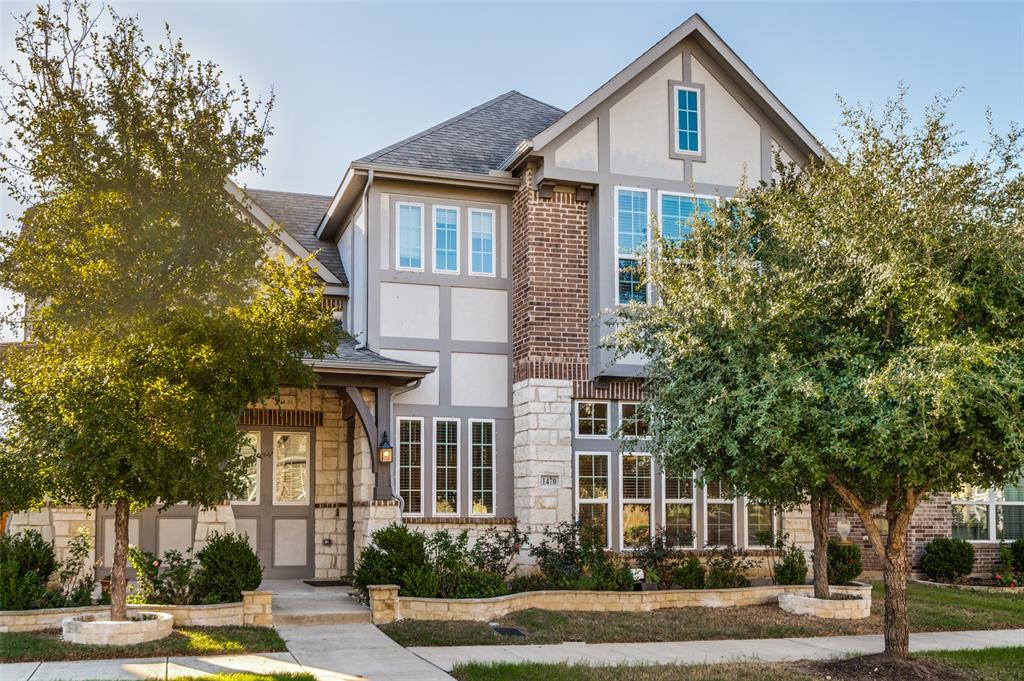 Two-story exterior featuring a mix of stone veneer, brick masonry, and timber-frame detailing, complemented by a gabled roofline and multiple multi-pane windows