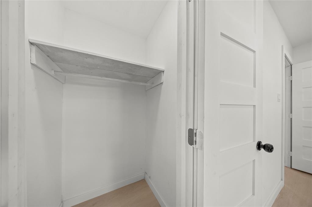 Closet featuring a built-in shelving unit, four-panel interior doors, and wood-finish flooring