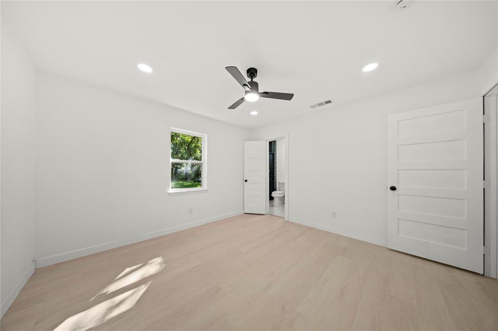Interior space featuring wood-finish flooring, recessed lighting, matte black ceiling fan, and five-panel interior doors with matte black hardware