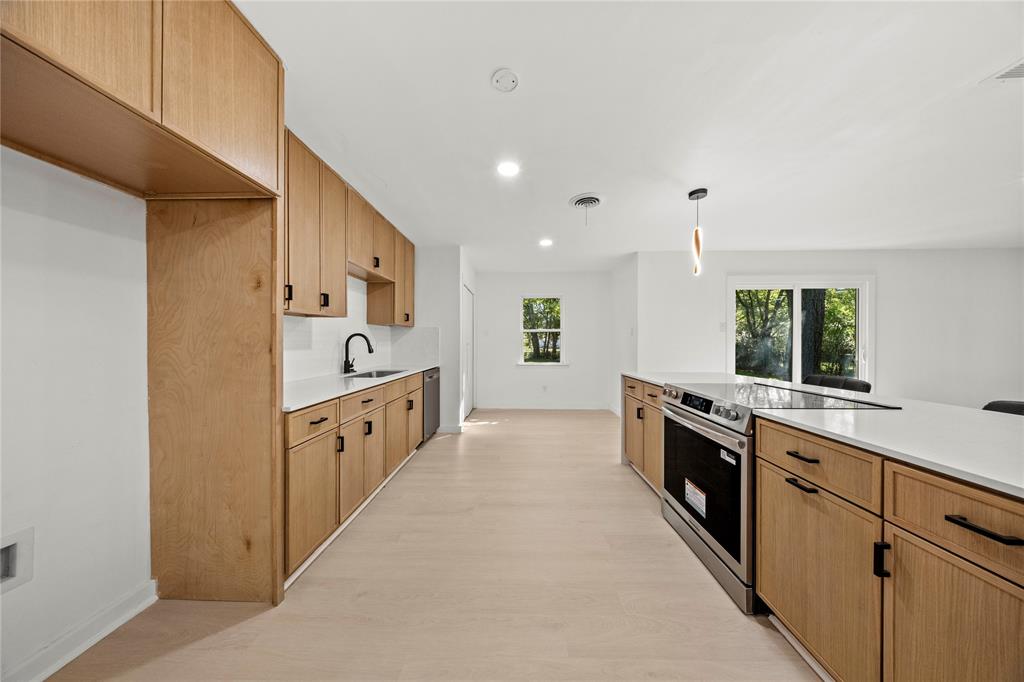 Kitchen featuring light-finish cabinetry, white countertops, stainless steel appliances, wood-finish flooring, and recessed lighting