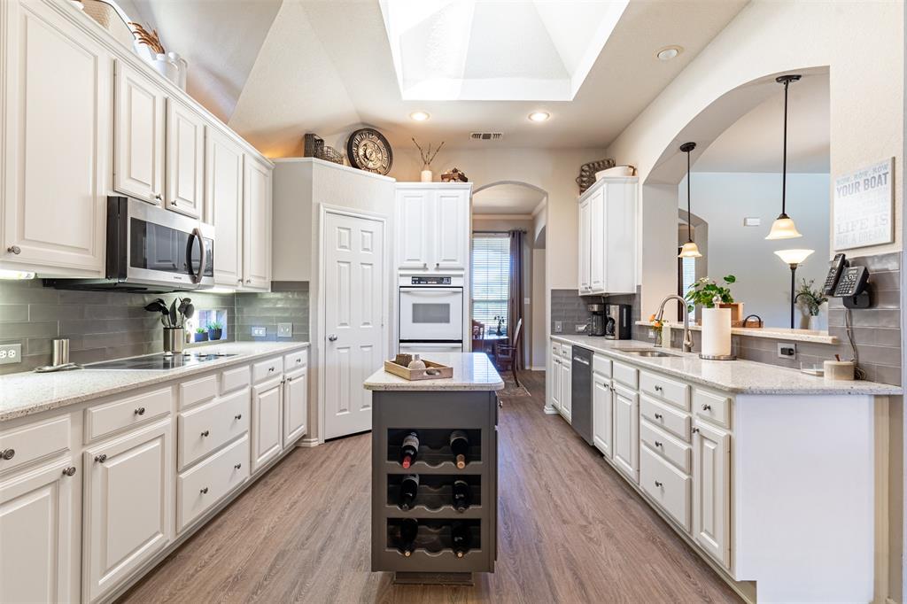 Kitchen features pristine white cabinetry with subway tile backsplash. Kitchen features pristine white cabinetry with subway tile backsplash.
