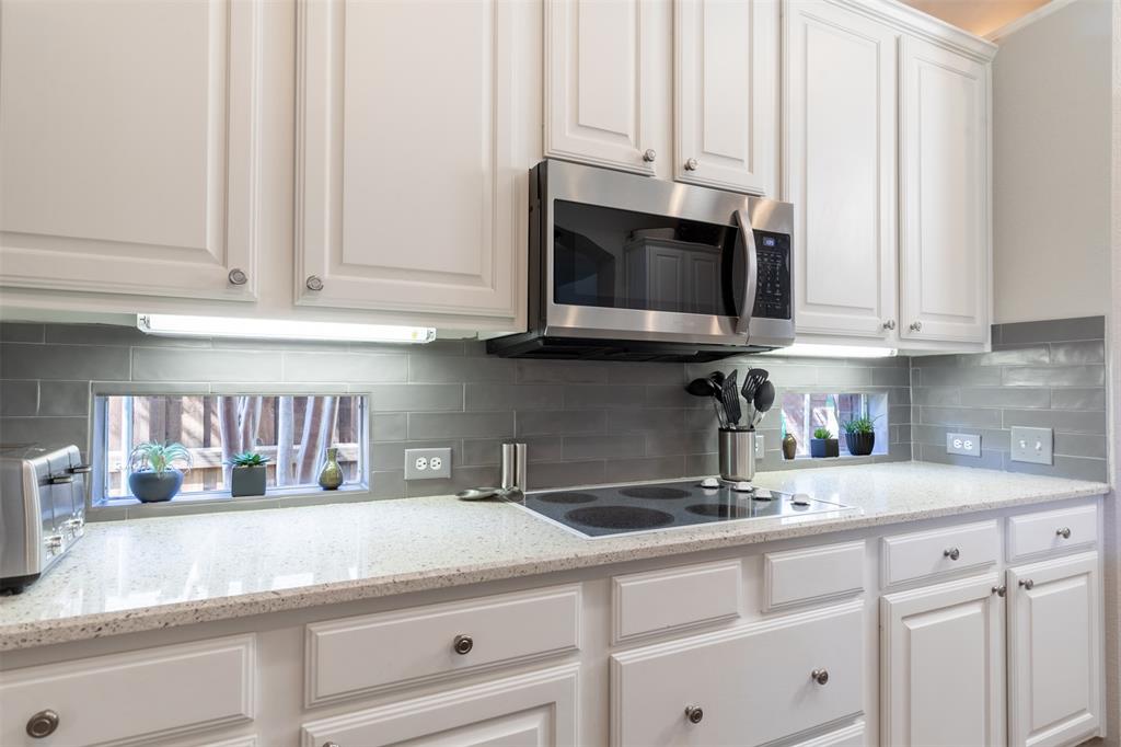 Kitchen with under-cabinet lighting and electric cooktop. Kitchen with under-cabinet lighting and electric cooktop.