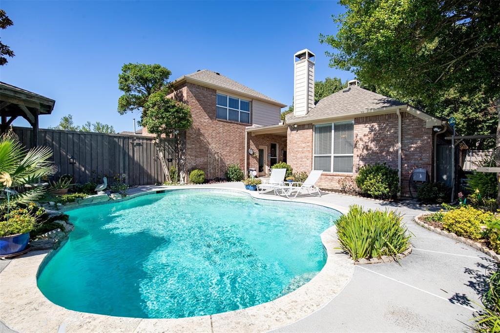 Backyard features bordered, lush landscaping.