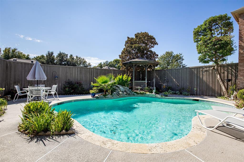 Beautiful backyard pool with multiple lounging areas.