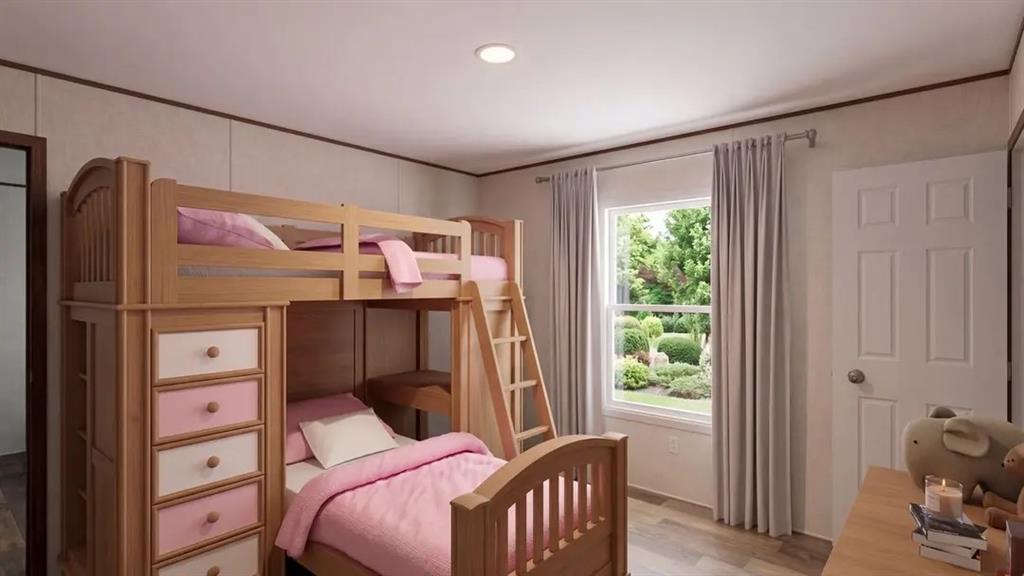 Room featuring wood-finish flooring, a recessed ceiling light, a six-panel door, and a dual-pane window with a view of manicured exterior landscaping