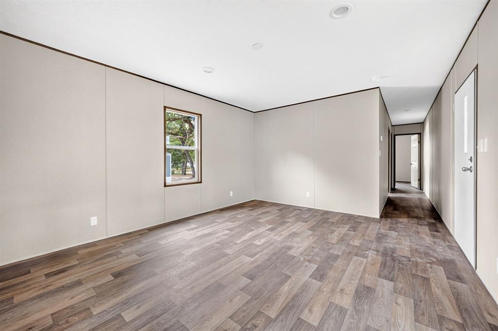 Wood-finish flooring throughout, recessed lighting, and a window with exterior views