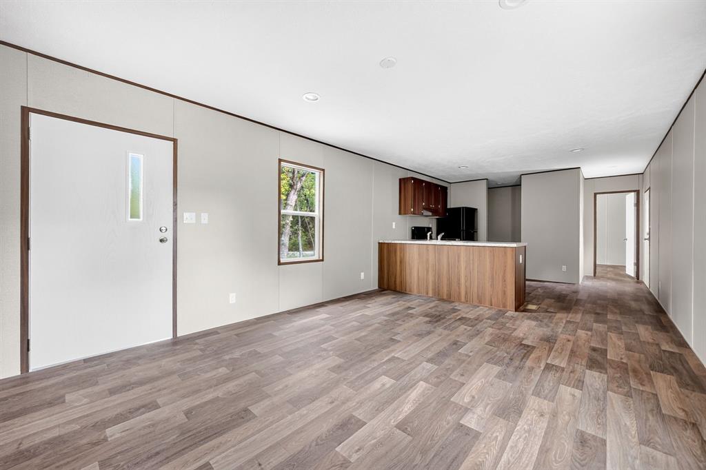 Open concept living area featuring wood-finish flooring, recessed lighting, and a kitchen island with a countertop