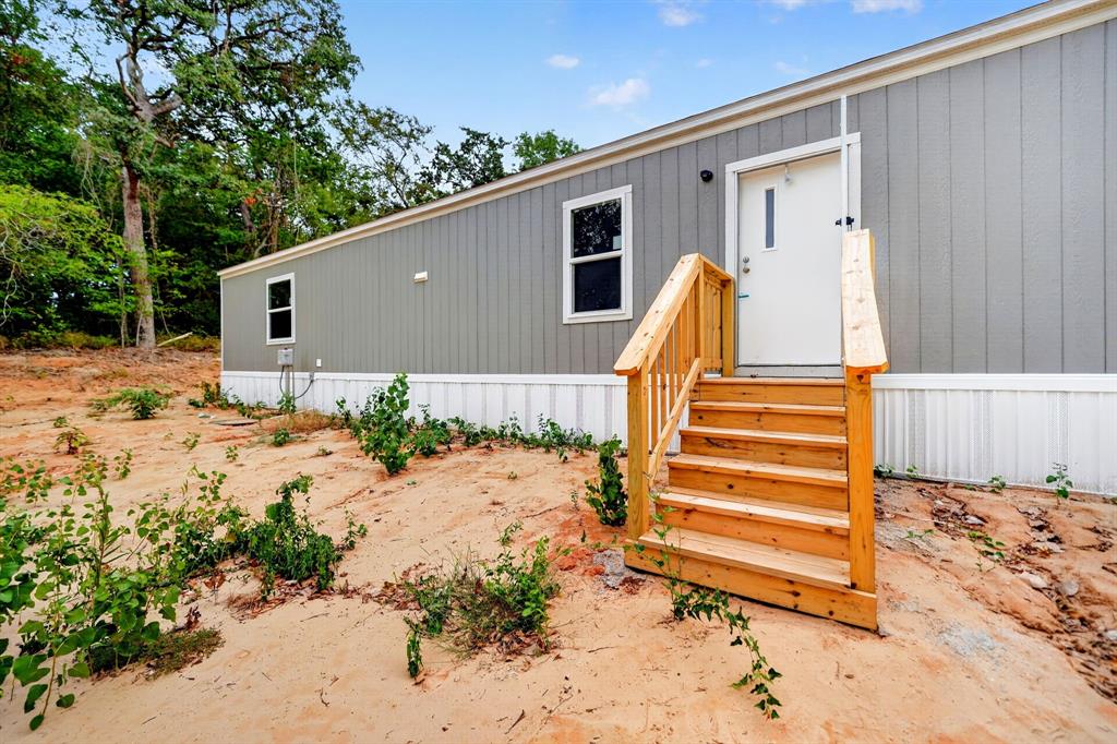 Entry featuring wood steps and railing