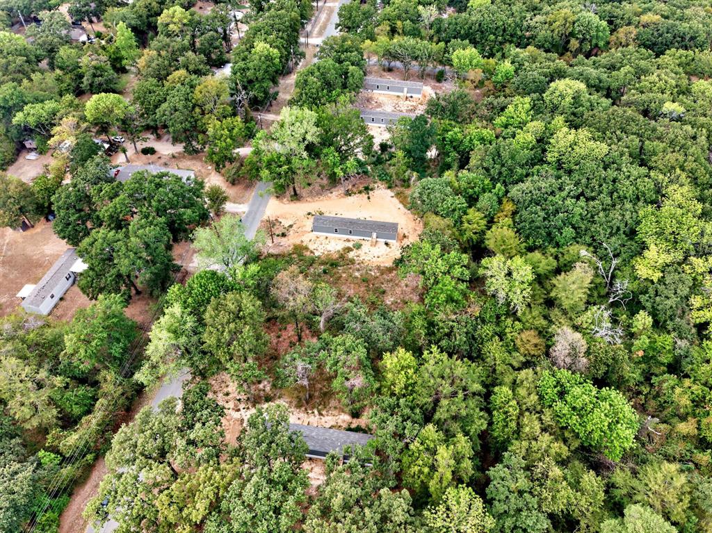 Wooded acreage featuring multiple residential structures and paved access
