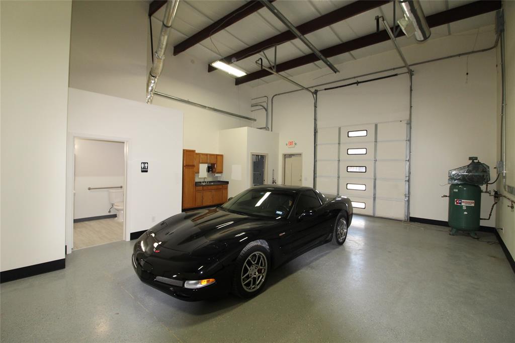 Another view of shop area, bathroom, kitchen area, rolling garage door, back door entrance.