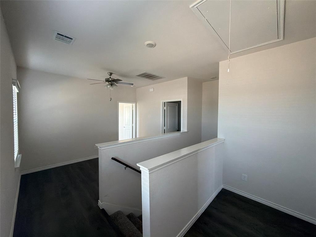 Wood-finish flooring, ceiling fan with integrated lighting, and neutral wall tones