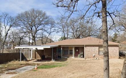 Single-story brick exterior featuring a covered carport and a concrete driveway