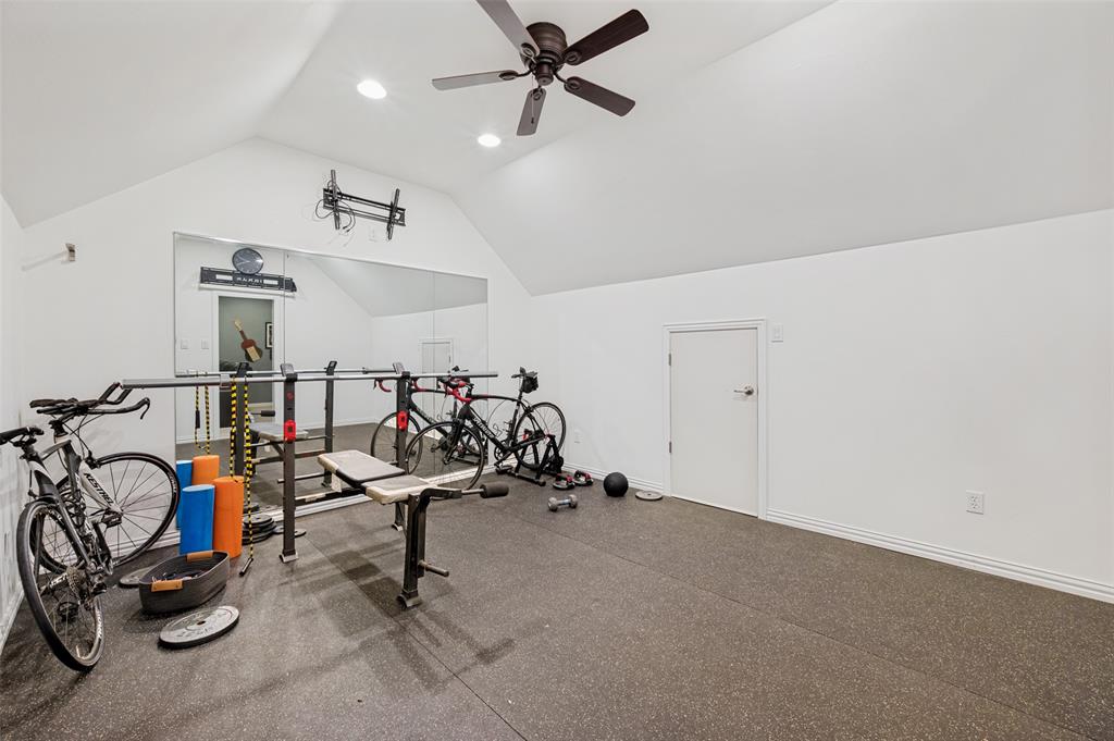 Vaulted ceiling with recessed lighting, ceiling fan, full-height wall mirror, and dedicated access door