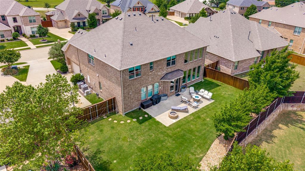 Brick exterior home with a gabled roof and a spacious backyard