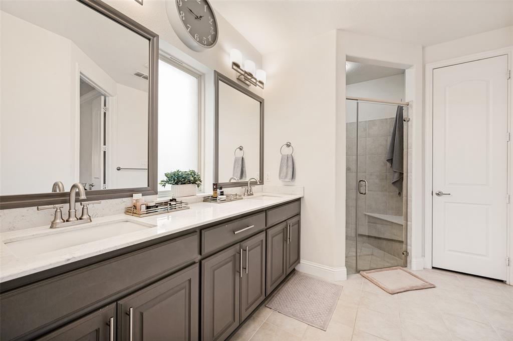 Double vanity with white countertops, undermount sinks, and dark wood-finish cabinetry