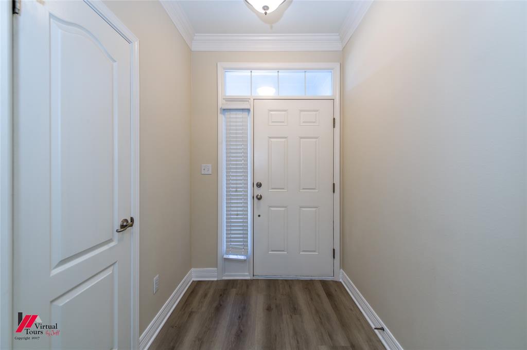 Entry featuring a six-panel door with transom and sidelight, crown molding, and wood-finish flooring