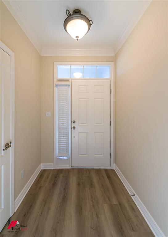 Entryway featuring wood-finish flooring, crown molding, a semi-flush mount ceiling fixture, and a six-panel door with a sidelight and transom window