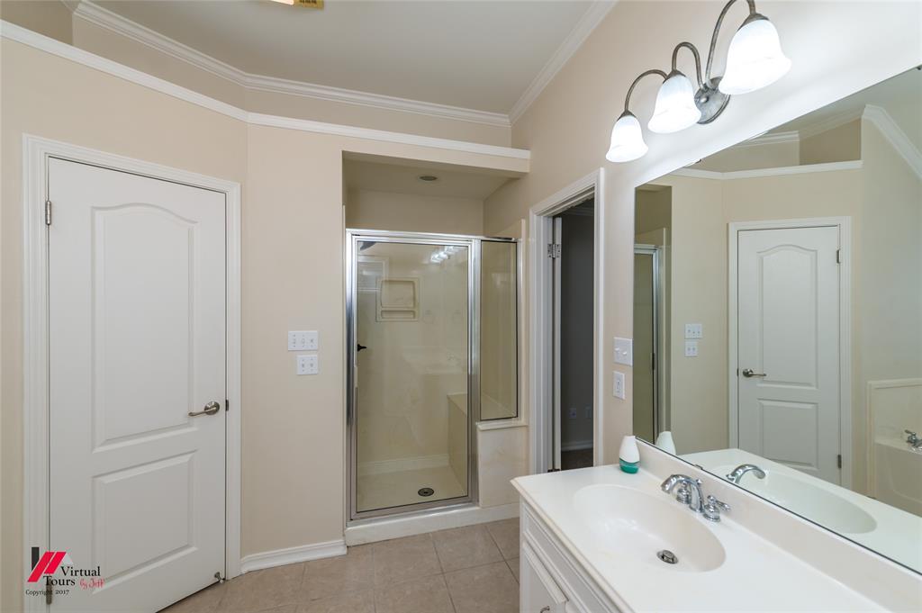 Vanity featuring a white countertop with an integrated oval basin, chrome faucet, wall-mounted mirror, and three-light overhead fixture