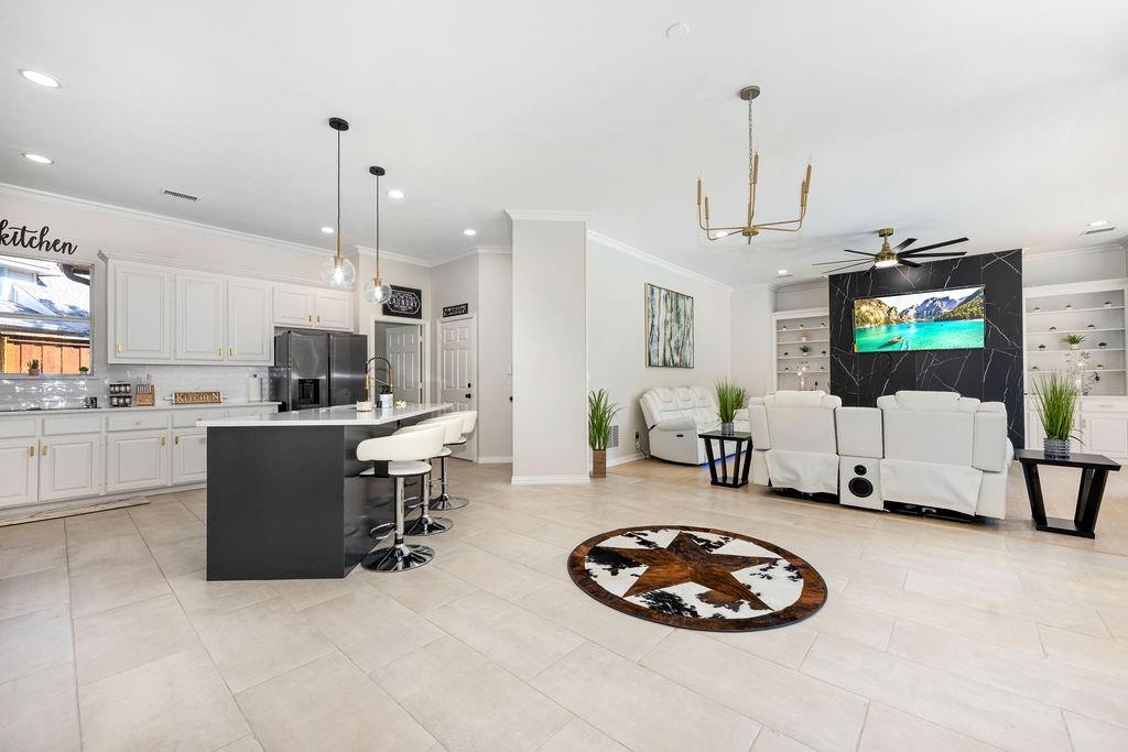 Open-concept living area featuring light-toned tile flooring and recessed lighting Open-concept living area featuring light-toned tile flooring and recessed lighting