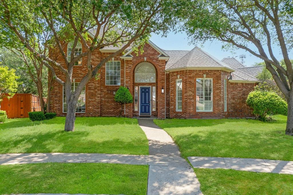Brick exterior with a prominent arched window, a blue front door, and a gabled roofline