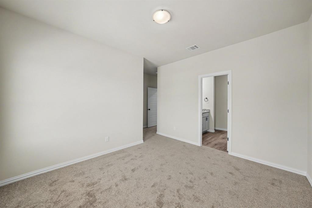 Neutral painted walls, carpeted flooring, overhead flush-mount lighting, and a white interior door frame