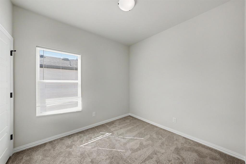 Neutral wall paint, carpeted flooring, white trim, and a flush mount ceiling light