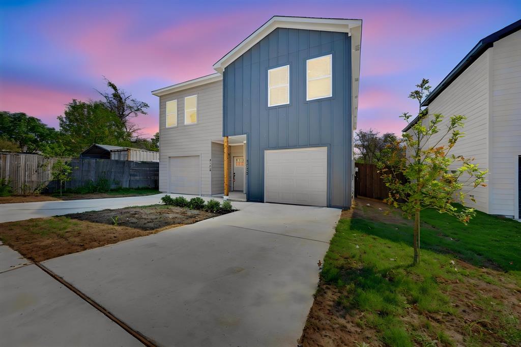 Modern exterior featuring vertical siding, a two-car garage, and concrete driveway
