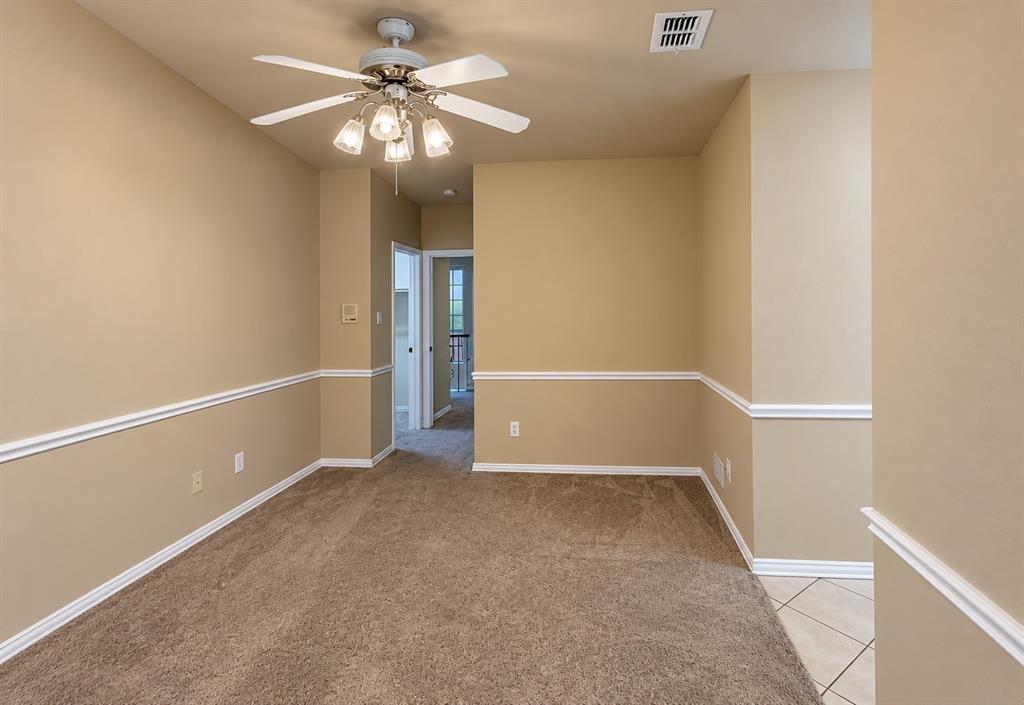 Carpeted room featuring a ceiling fan with integrated lighting, chair rail molding, and a neutral color palette