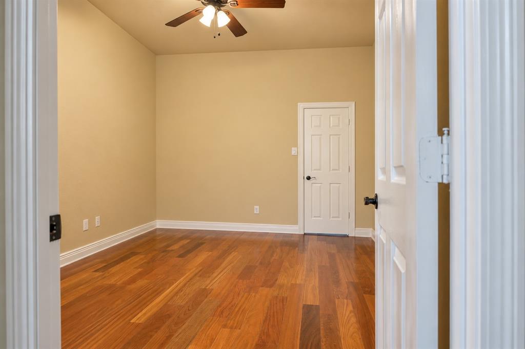 Warm wood-finish flooring, neutral wall tones, and crown molding