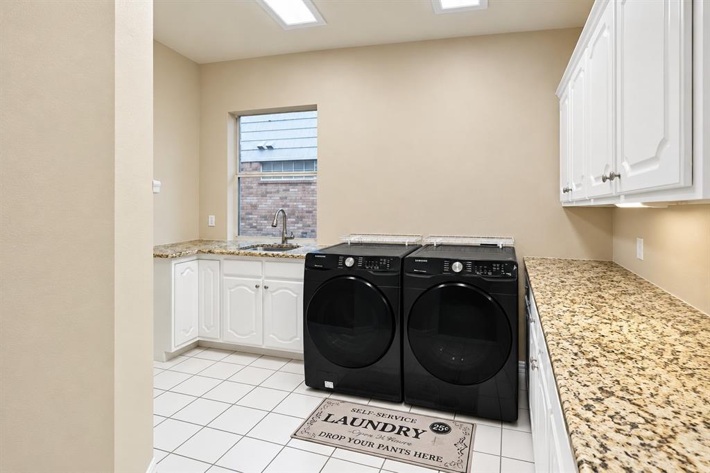 White tile flooring, white cabinetry, granite-finish countertops, stainless steel sink with a gooseneck faucet, and recessed ceiling lighting