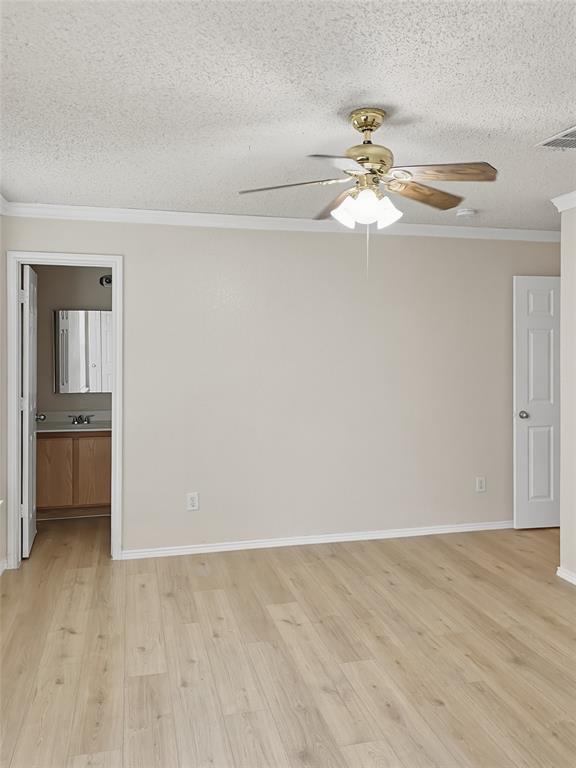 Spacious primary living area featuring wood-finish plank flooring, neutral walls, and abundant natural light