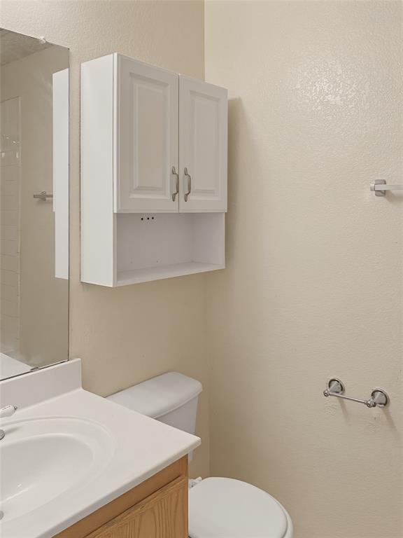 Wood-finish vanity with an integrated white sink and mirror