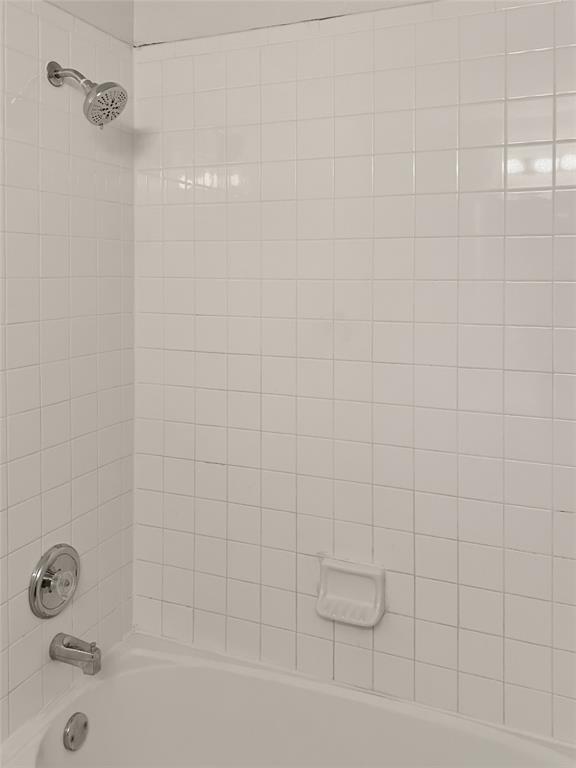 White tiled shower surround with a built-in tub