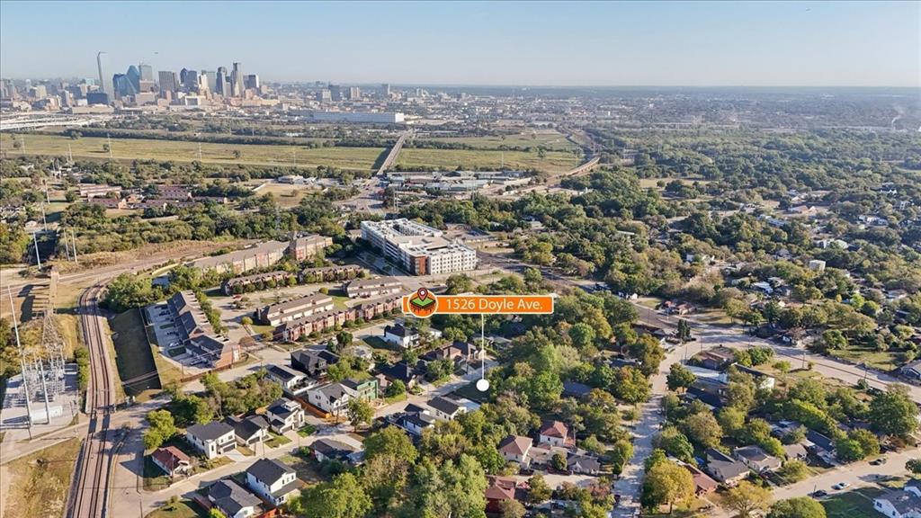 Aerial perspective showcasing a residential area with varied housing styles, mature trees, and urban infrastructure