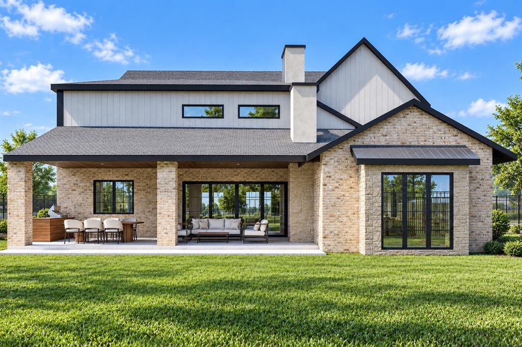 Two-story residential exterior featuring light-toned brick masonry, vertical siding, an expansive covered rear patio, a built-in outdoor kitchen, and large-format multi-panel windows